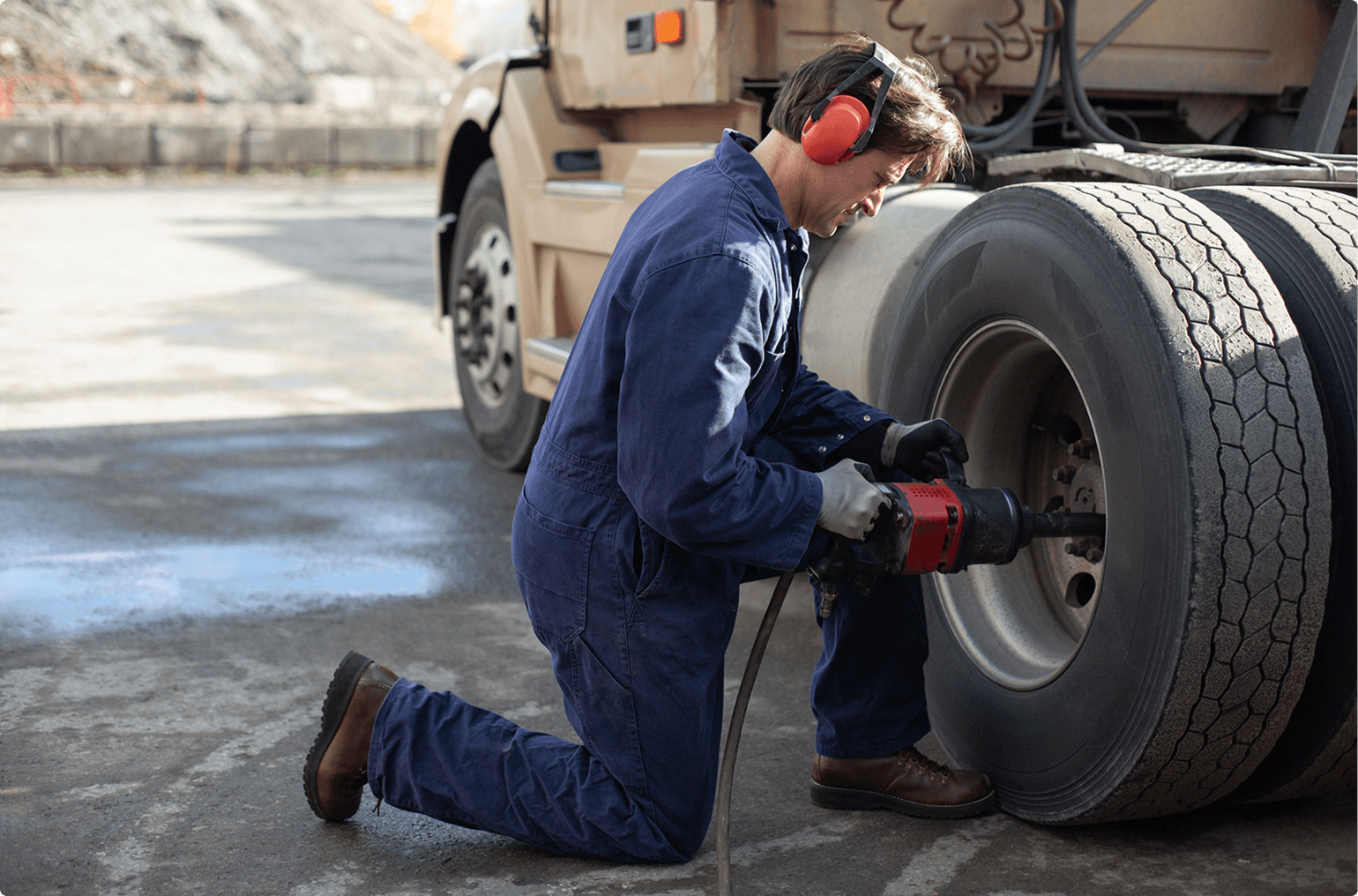 Worker in blue overalls repairing tire